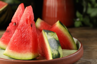 Photo of Plate with slices of juicy watermelon on wooden table, closeup. Space for text