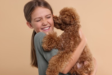 Little child with cute puppy on beige background. Lovely pet