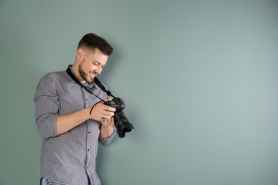 Male photographer with camera on grey background