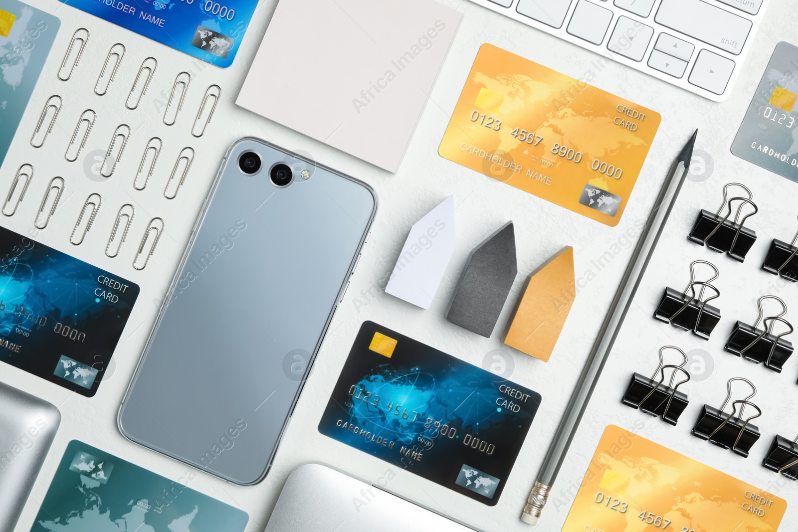 Photo of Flat lay composition with credit cards, smartphone and stationery on white table