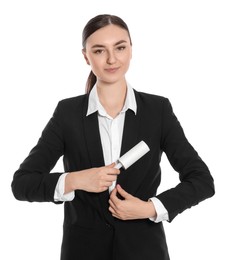 Young woman cleaning suit with lint roller on white background