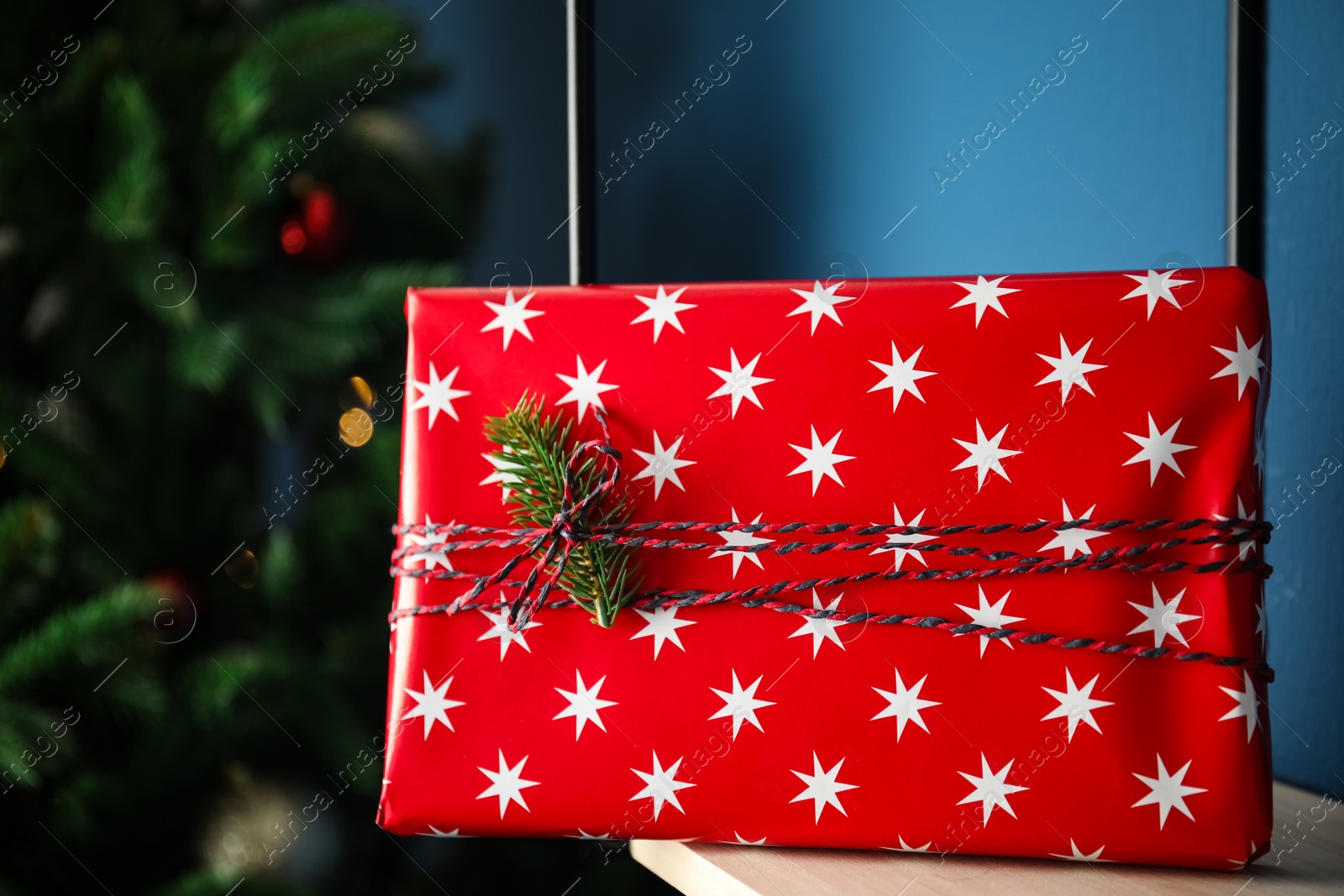 Photo of Beautifully wrapped gift box on rack indoors