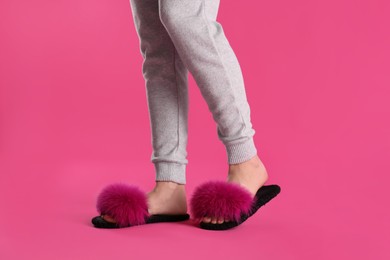 Photo of Woman in fluffy slippers on pink background, closeup