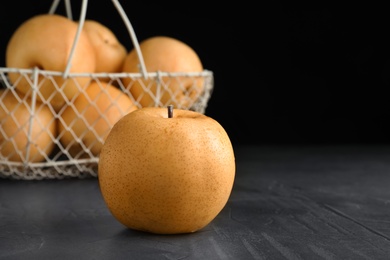 Photo of Ripe apple pear on black table. Space for text