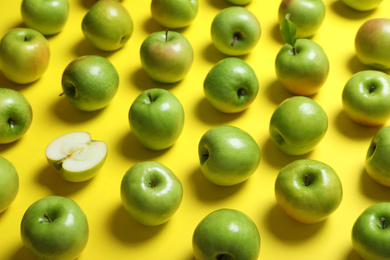 Photo of Many tasty green apples on yellow background