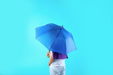 Photo of Man with blue umbrella on color background