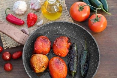 Photo of Frying pan and ingredients for salsa sauce on wooden table, flat lay
