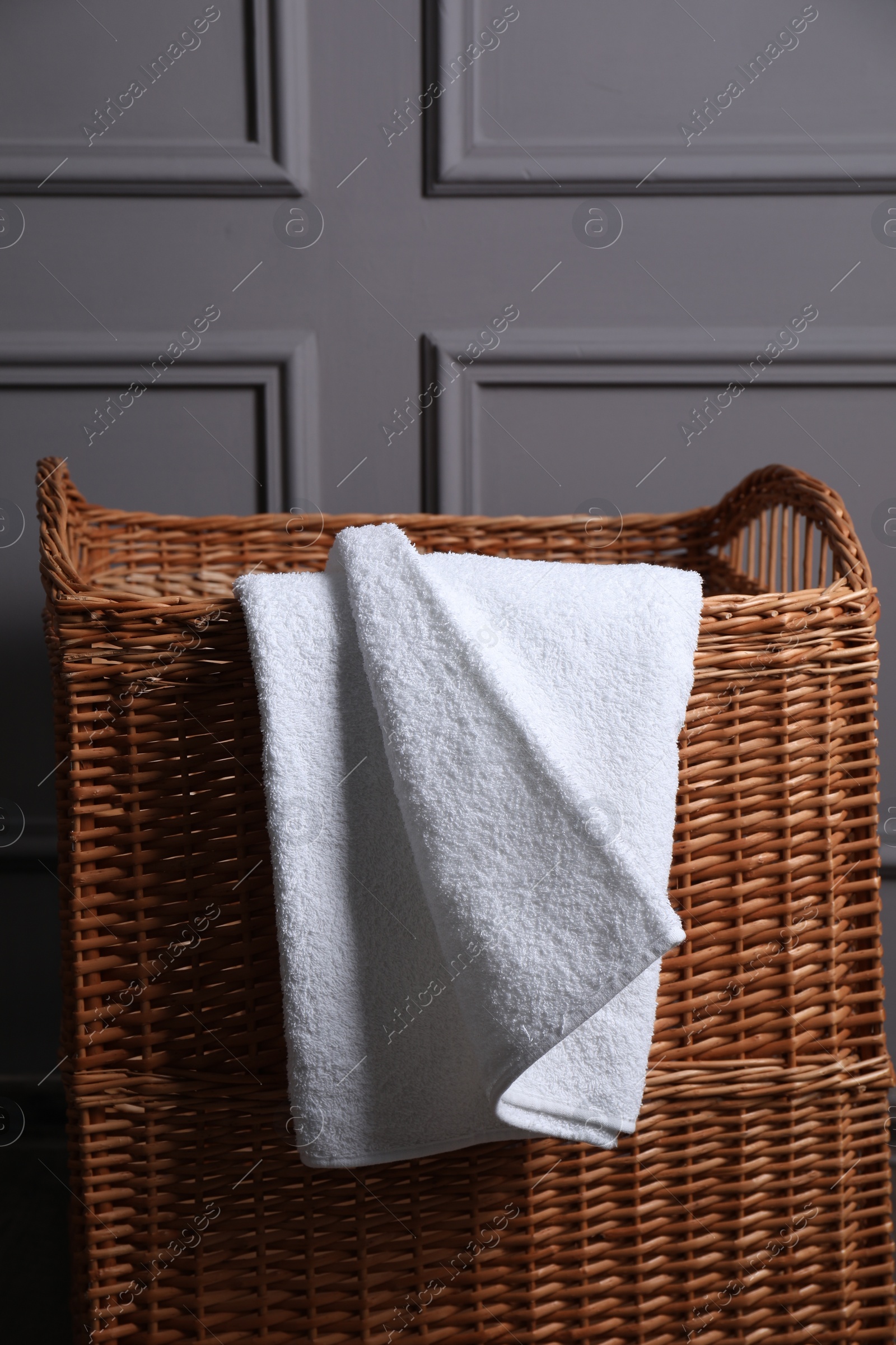 Photo of Soft terry towel on rattan laundry basket indoors