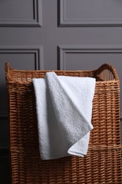 Soft terry towel on rattan laundry basket indoors