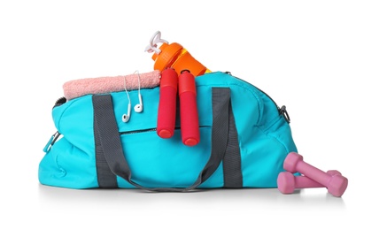 Photo of Sports bag and gym equipment on white background