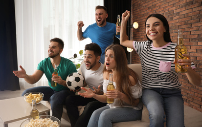 Group of friends watching football at home