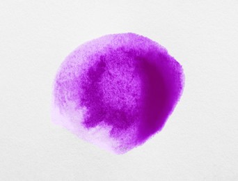 Photo of Blot of purple ink on white background, top view