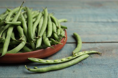 Photo of Fresh green beans on blue wooden table, closeup