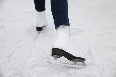 Photo of Woman skating along ice rink outdoors, closeup