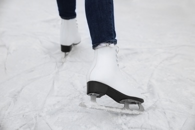 Woman skating along ice rink outdoors, closeup