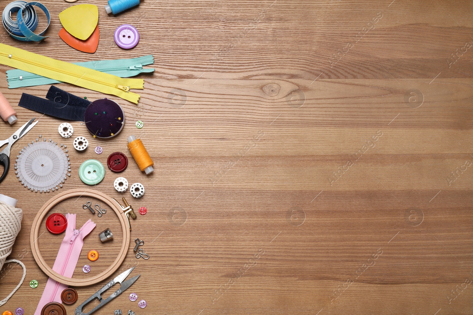 Photo of Flat lay composition with different sewing accessories on wooden background. Space for text