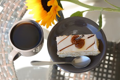 Tasty dessert, cup of fresh aromatic coffee and flower on glass table outdoors, above view