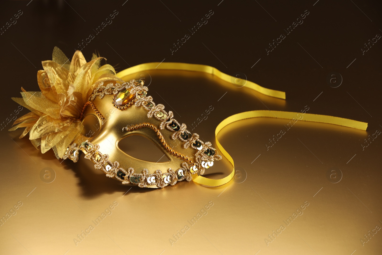 Photo of Beautifully decorated face mask on beige background. Theatrical performance