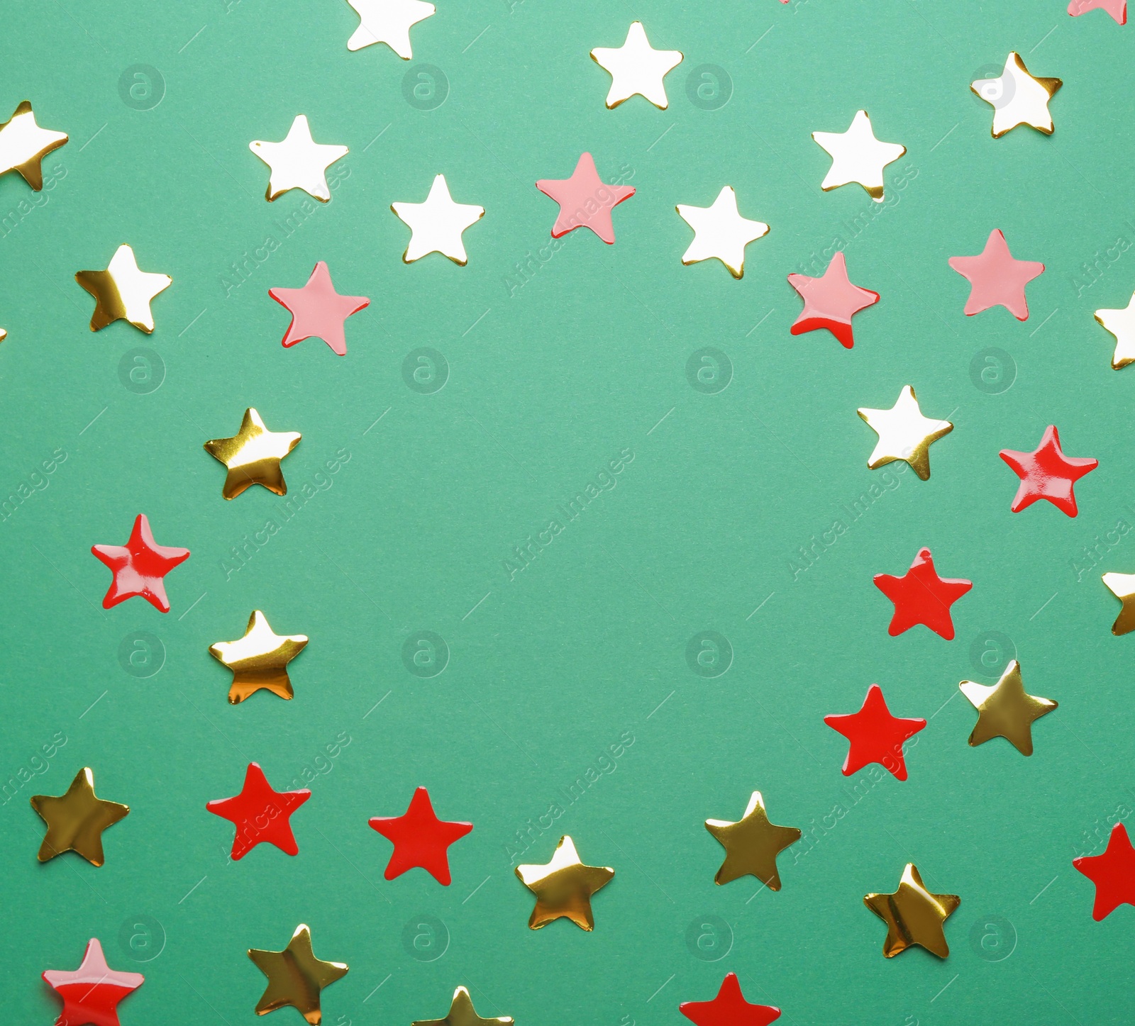 Photo of Frame made of confetti stars with space for text on green background, top view. Christmas celebration