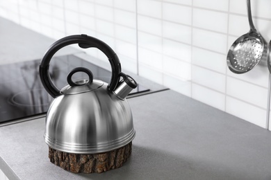 Modern kettle on kitchen counter indoors, space for text
