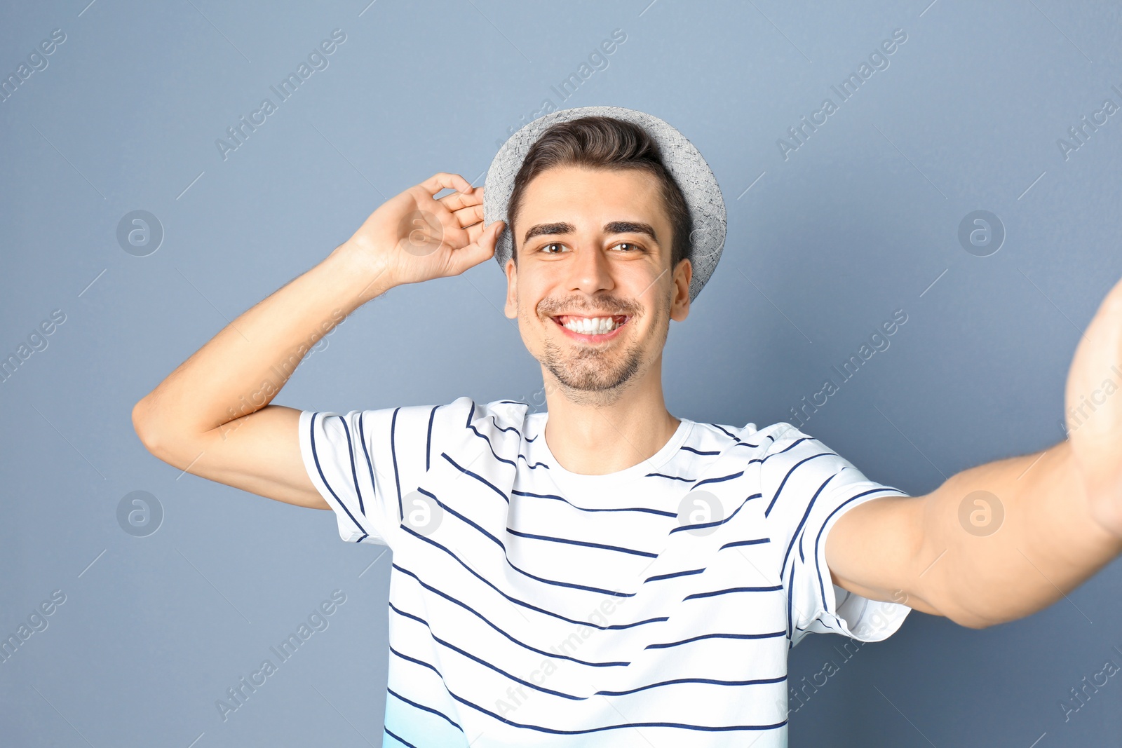 Photo of Young handsome man taking selfie against grey background