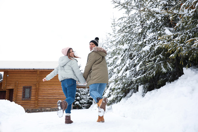 Lovely couple spending time together on snowy day. Winter vacation