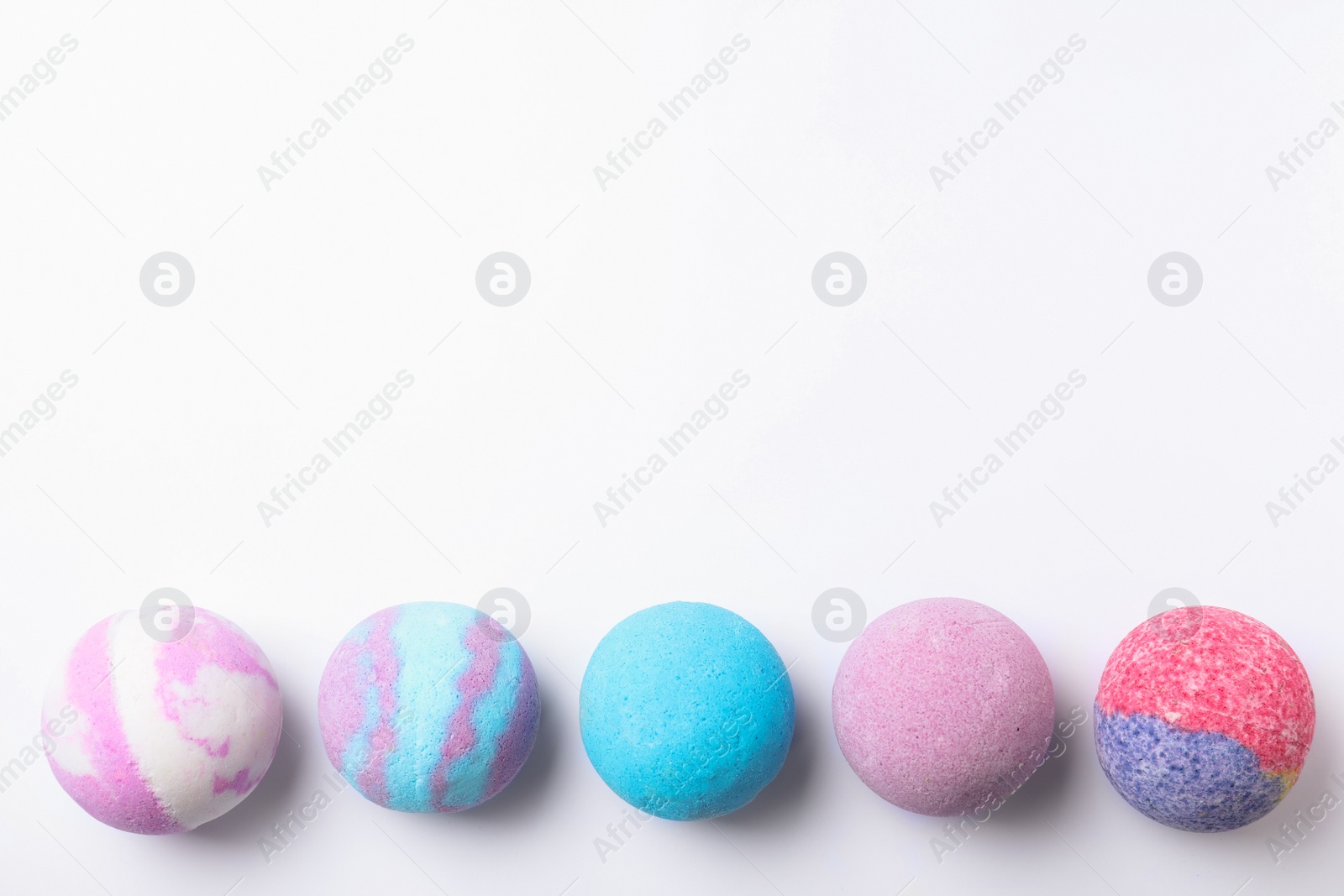 Photo of Colorful bath bombs on white background, flat lay. Space for text