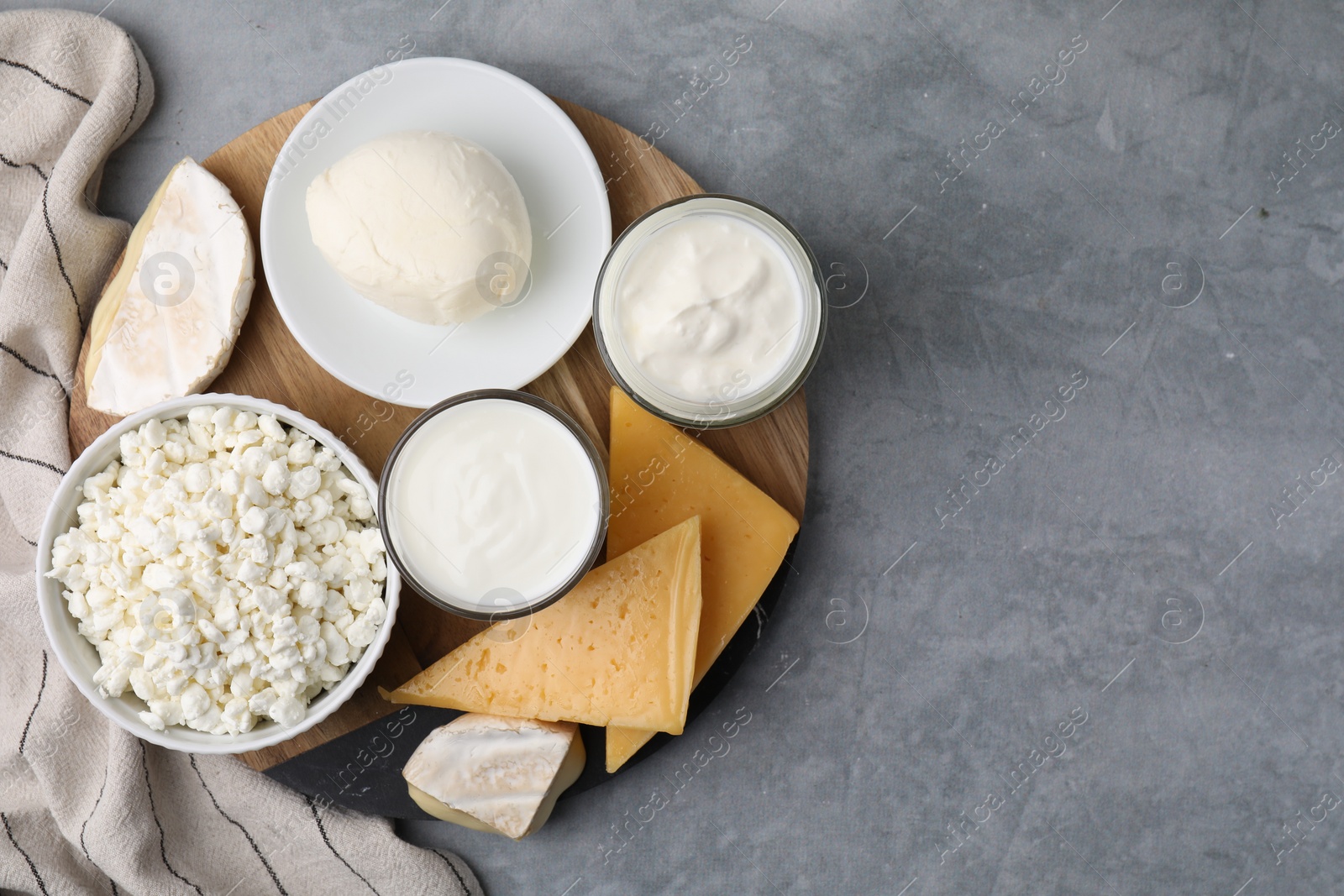 Photo of Different fresh dairy products on grey table, top view. Space for text