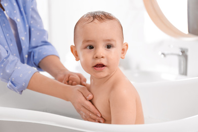 Photo of Mother with her little baby in bathroom