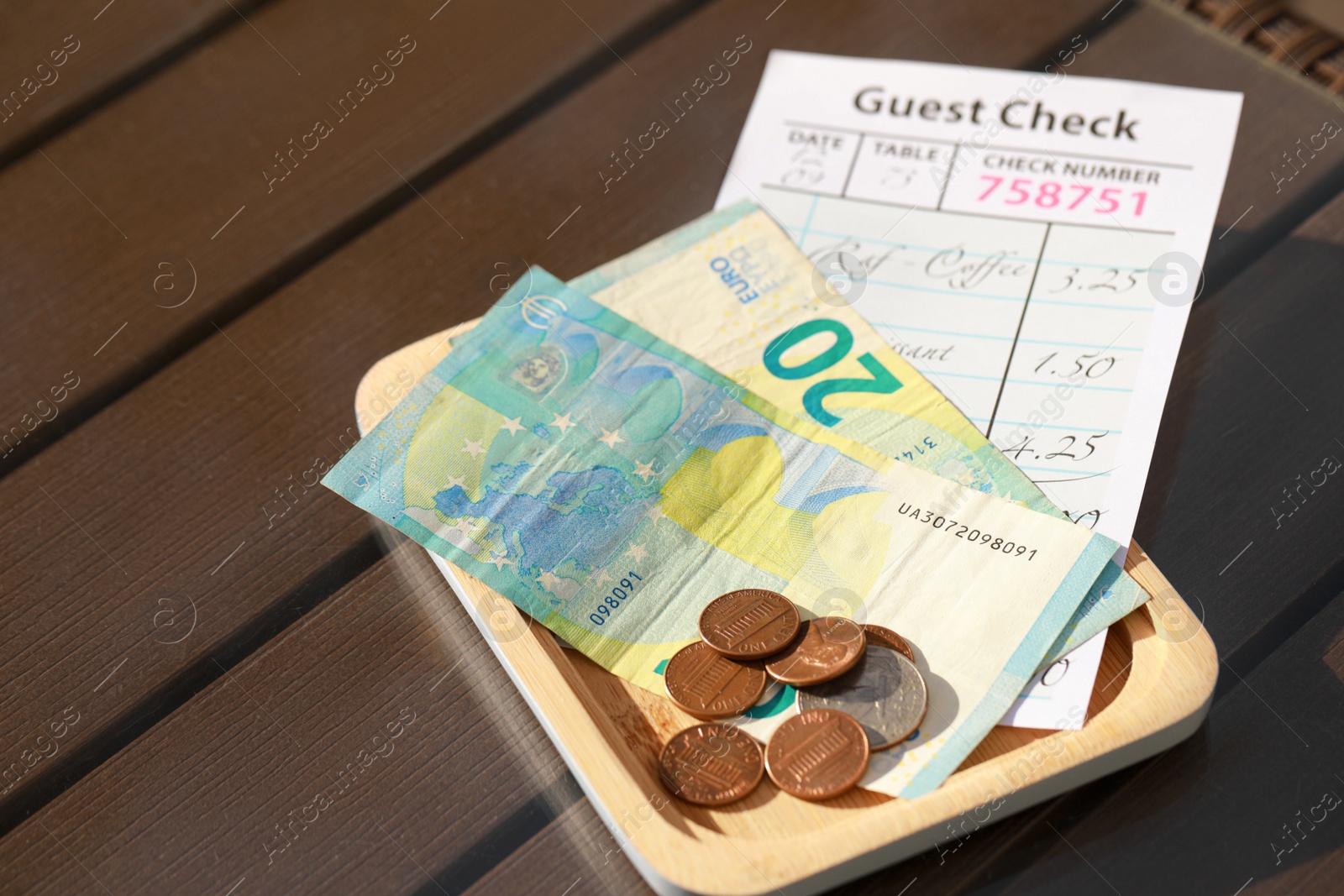 Photo of Wooden plate with payment for order and receipt on table, closeup. Leave tip