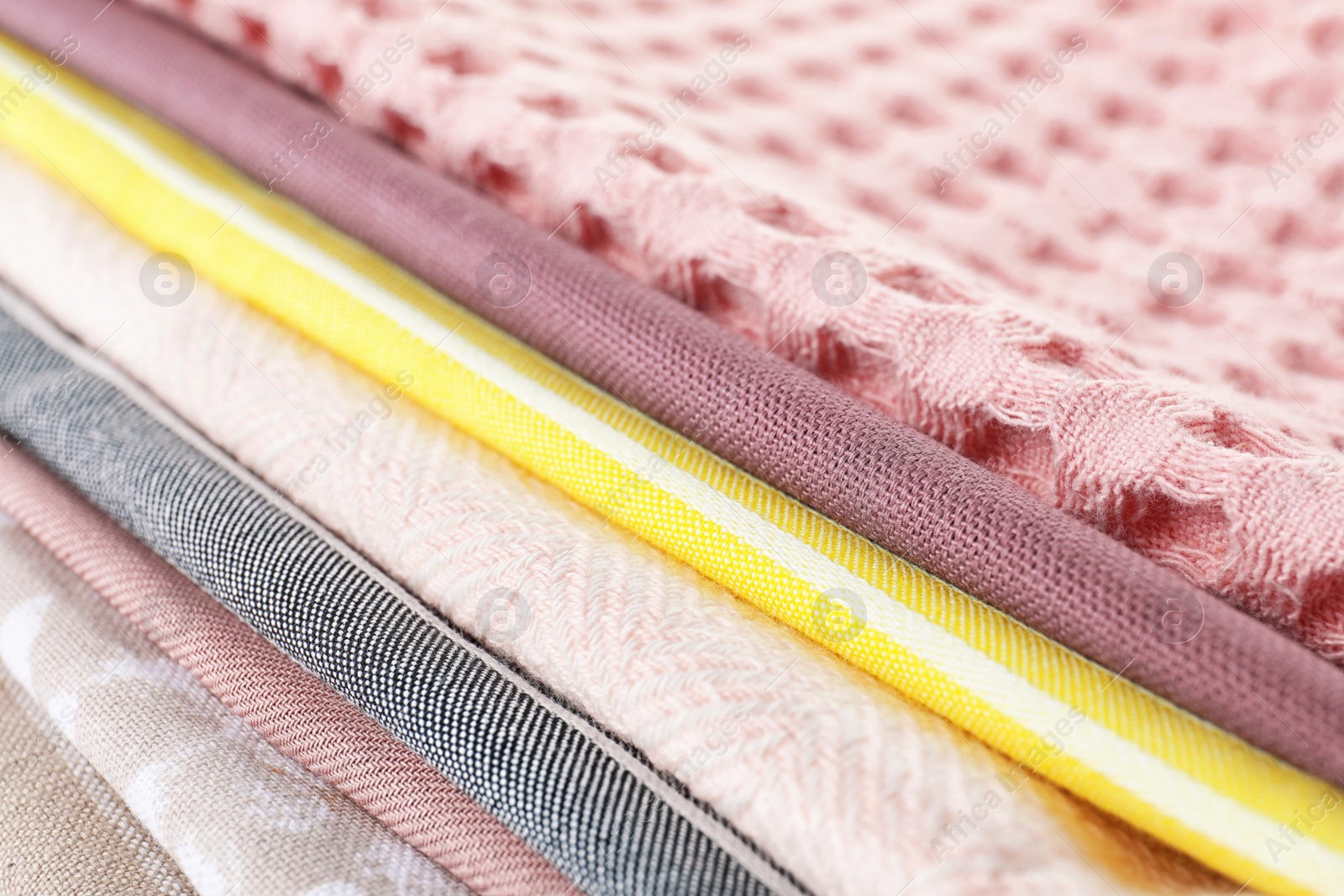 Photo of Different folded fabric napkins as background, closeup view