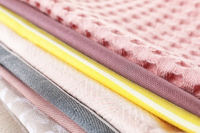 Different folded fabric napkins as background, closeup view