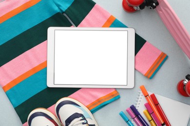 Modern tablet, clothes and stationery on light background, flat lay. Space for text