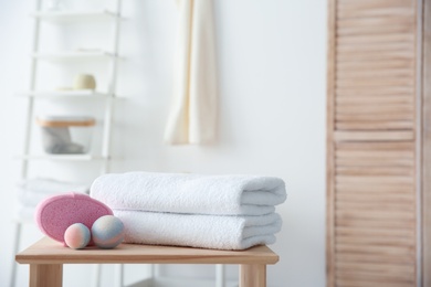 Clean towels and toiletries on table against blurred background