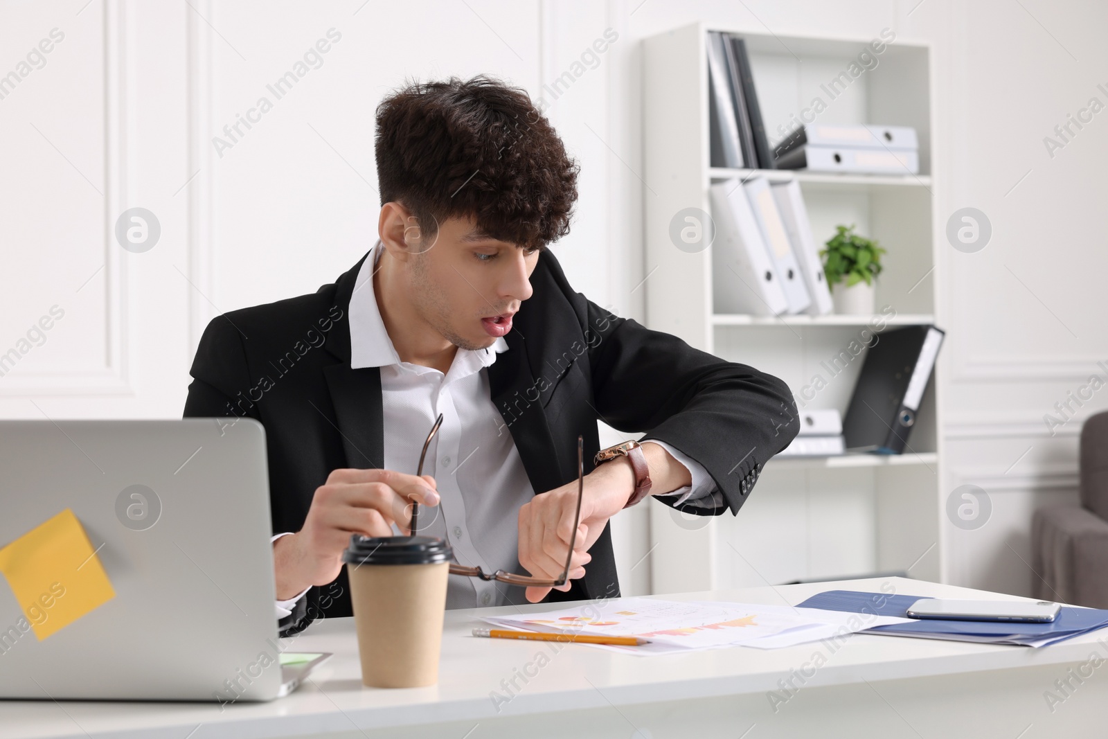 Photo of Emotional young man working at table in office. Deadline concept