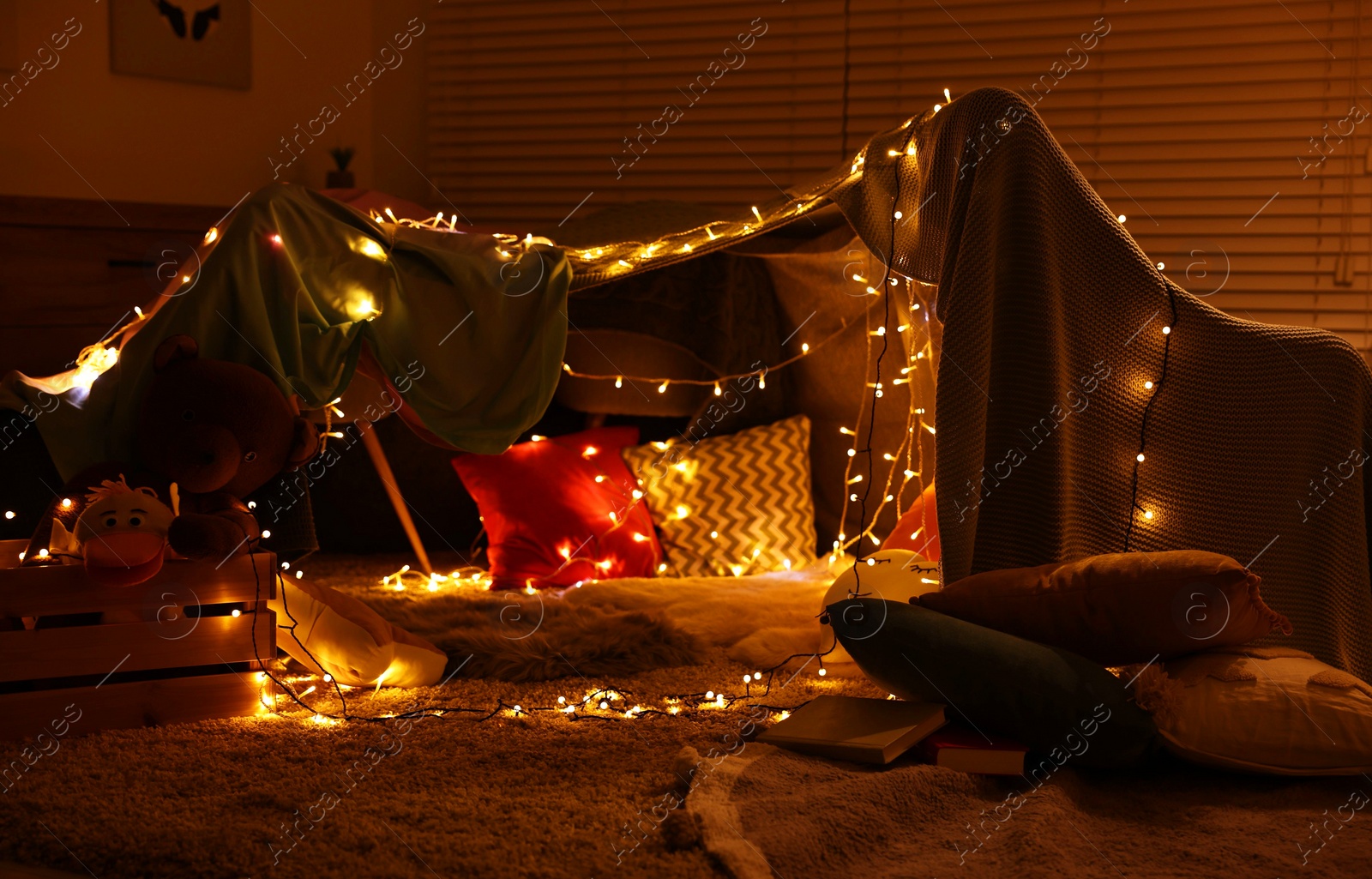 Photo of Beautiful play tent decorated with festive lights at home