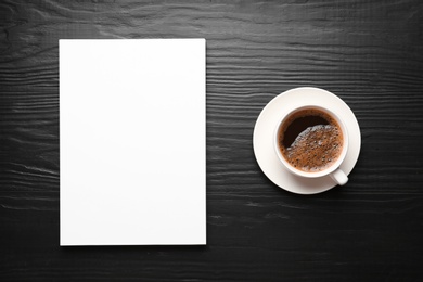 Blank paper sheets for brochure and cup of coffee on black wooden background, flat lay. Mock up