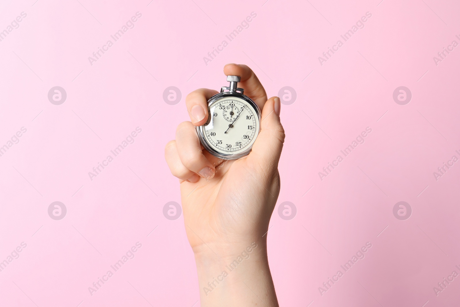 Photo of Woman holding vintage timer on pink background, closeup