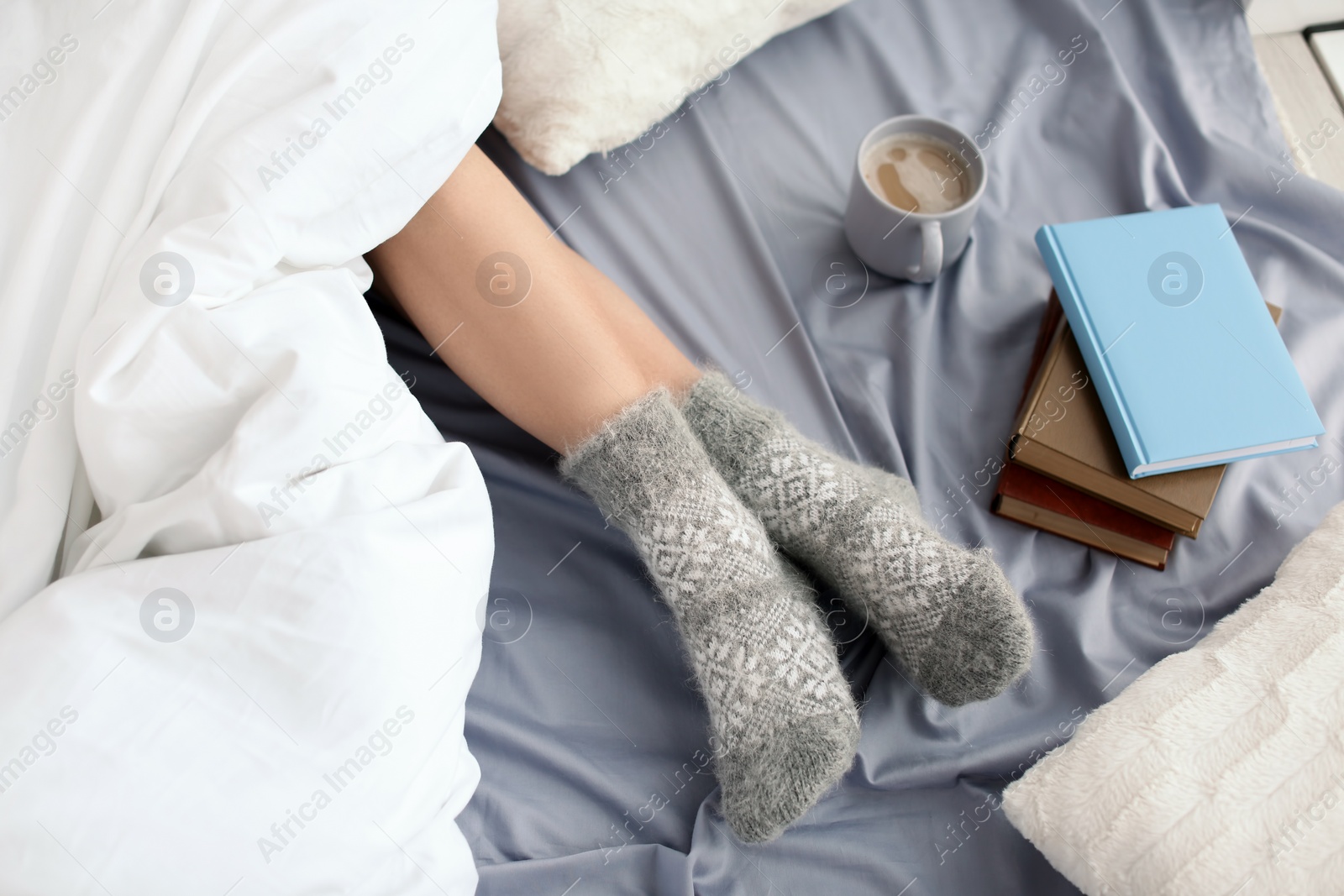 Photo of Young woman lying on bed, closeup view of legs. Winter atmosphere