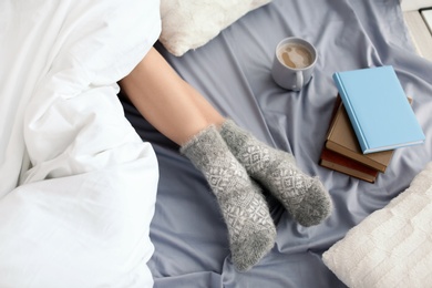 Young woman lying on bed, closeup view of legs. Winter atmosphere