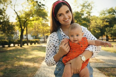 Photo of Portrait of young mother with her cute baby in park on sunny day