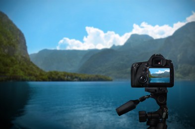 Taking photo of beautiful river and mountains with camera mounted on tripod