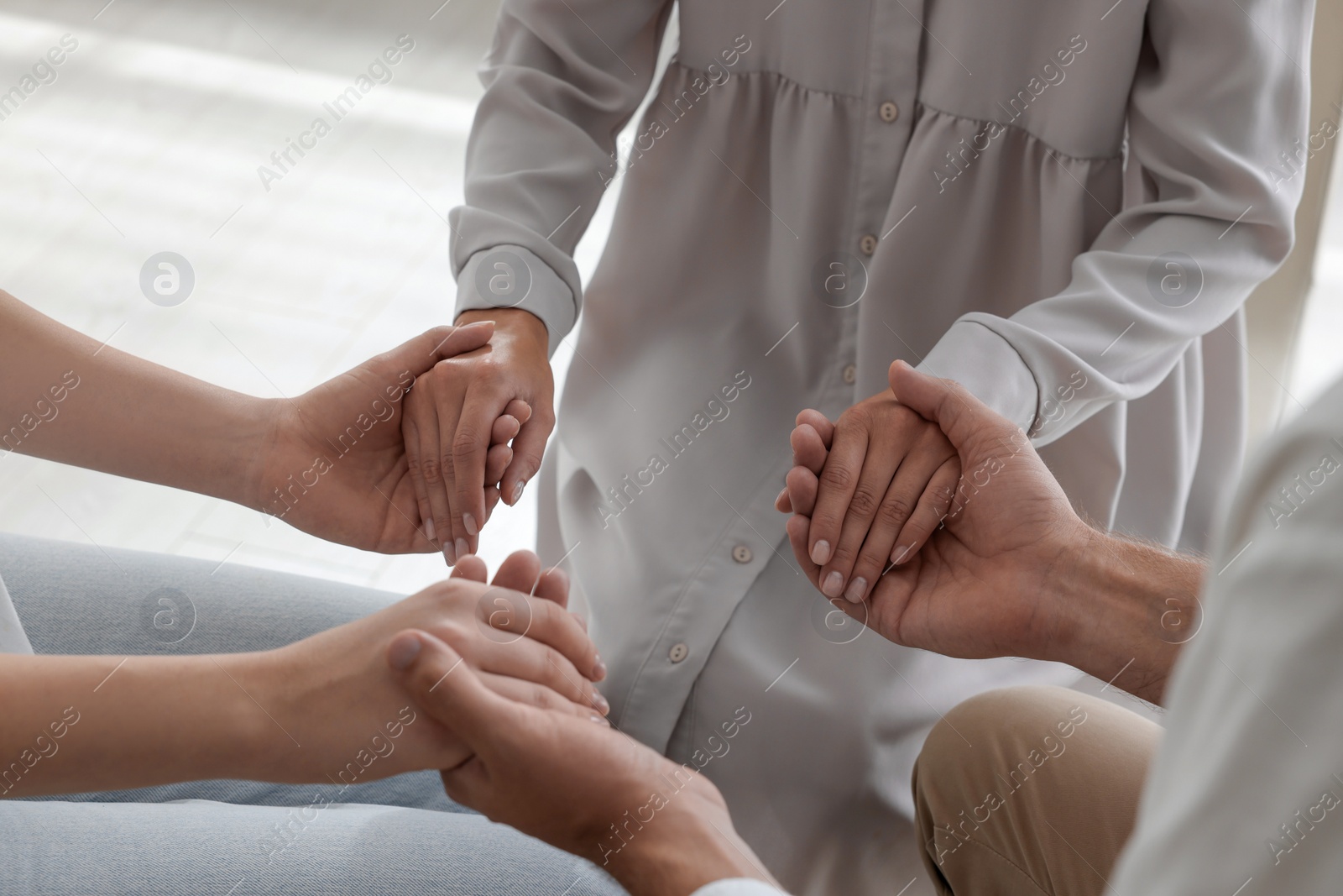 Photo of Group of religious people holding hands and praying together indoors, closeup