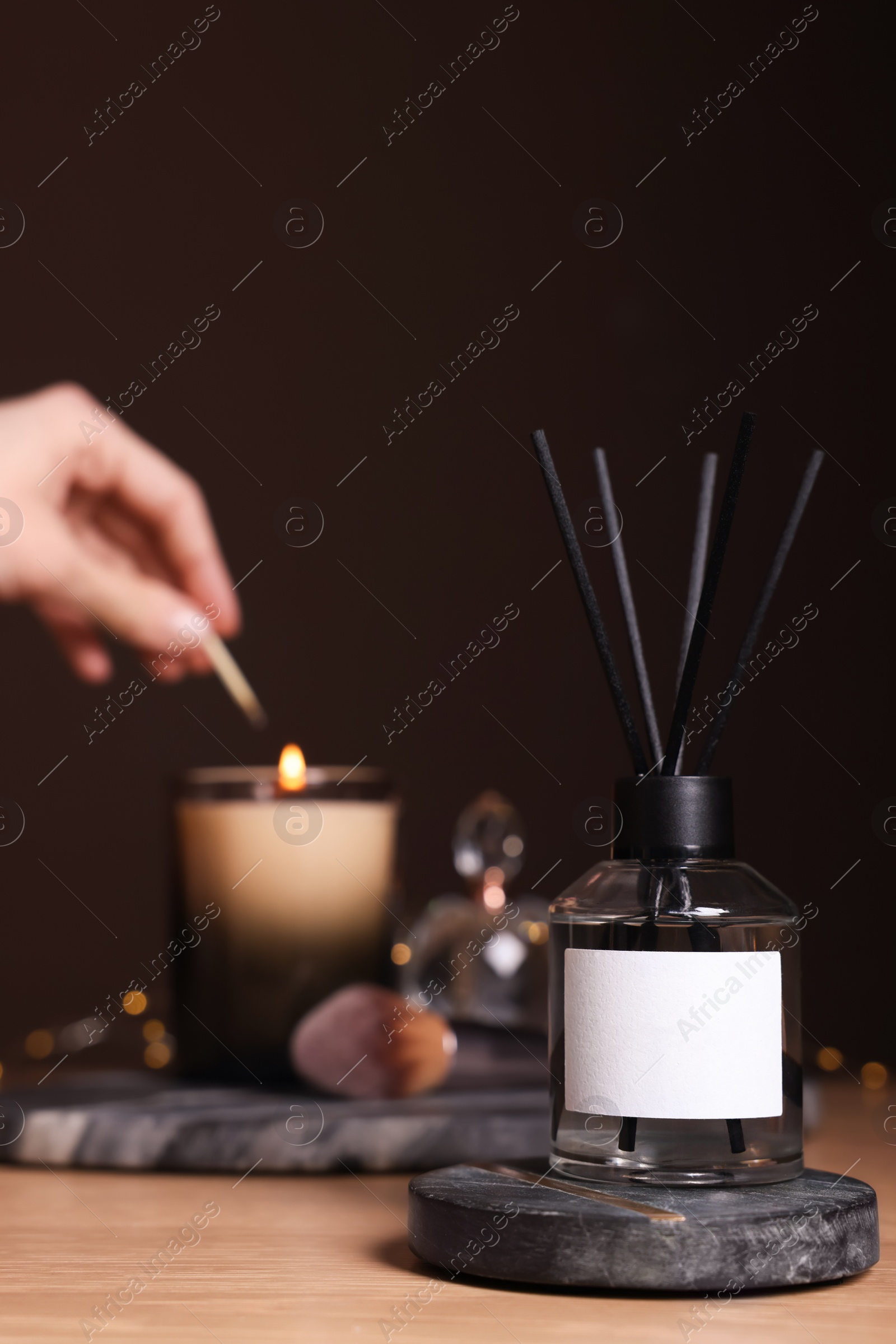 Photo of Aromatic reed air freshener on wooden table, space for text