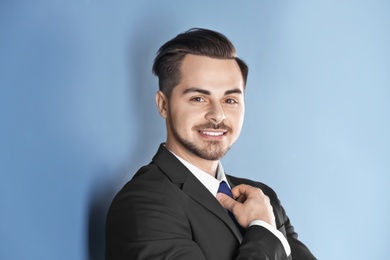 Portrait of young man with beautiful hair on color background