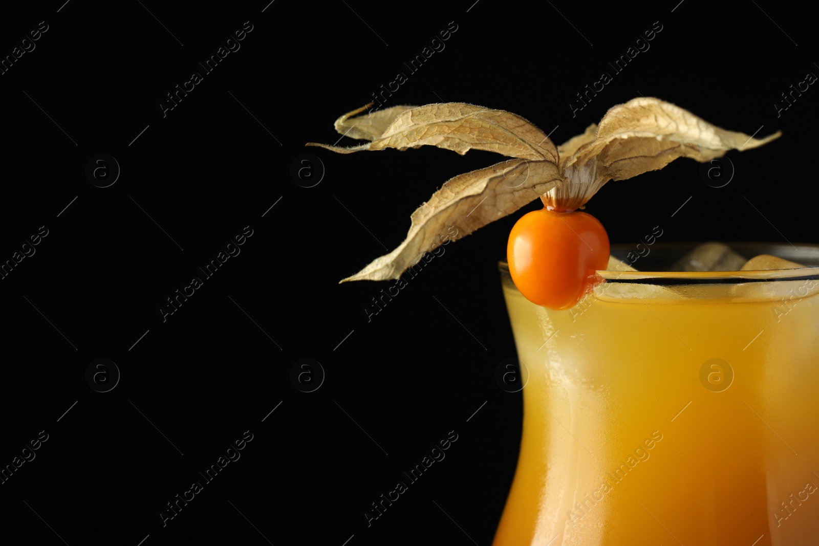 Photo of Tasty cocktail decorated with physalis fruit on black background, closeup. Space for text