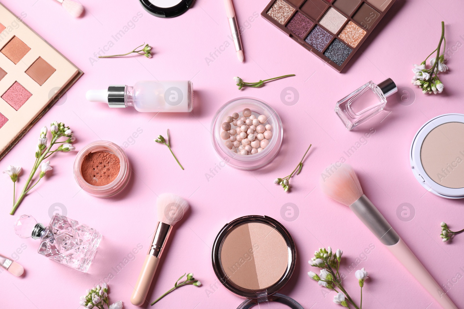 Photo of Flat lay composition with different makeup products and beautiful spring flowers on pink background