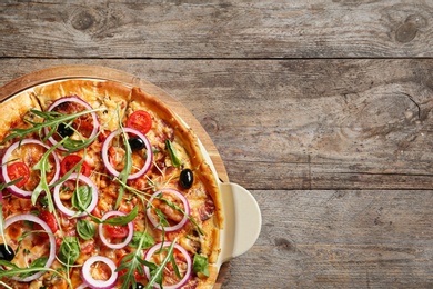 Photo of Tasty homemade pizza and space for text on wooden table, top view