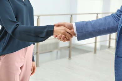 Photo of Real estate agent shaking hands with client in new apartment, closeup
