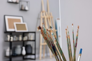 Photo of Closeup view of paintbrushes in artist's studio, space for text